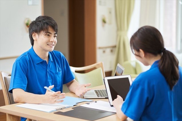 生活相談員がケア内容を職員に共有している写真